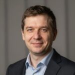 Профессиональный портрет уверенного российского бизнесмена на размытом нейтральном фоне для сайта строительных услуг