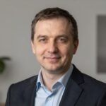 Профессиональный портрет уверенного российского бизнесмена на размытом нейтральном фоне для сайта строительных услуг
